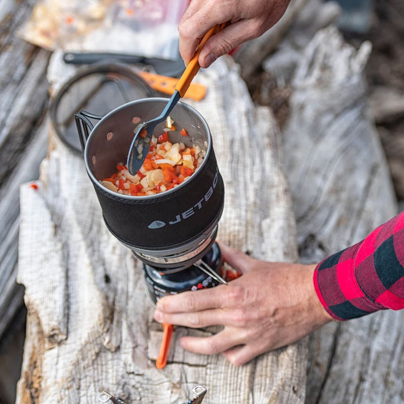 Person cooking with the Jetboil MiniMo on a log