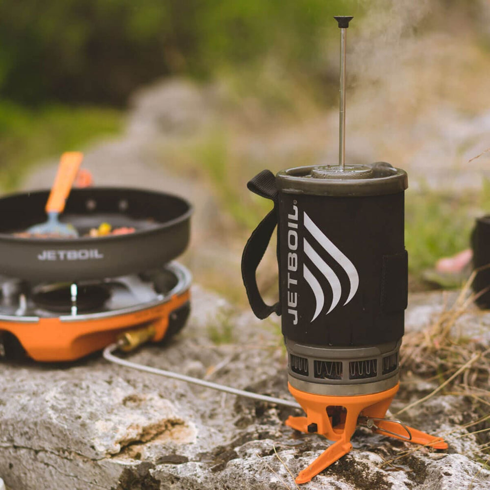 Jetboil Luna Satellite Burner cooking on a rock outdoors