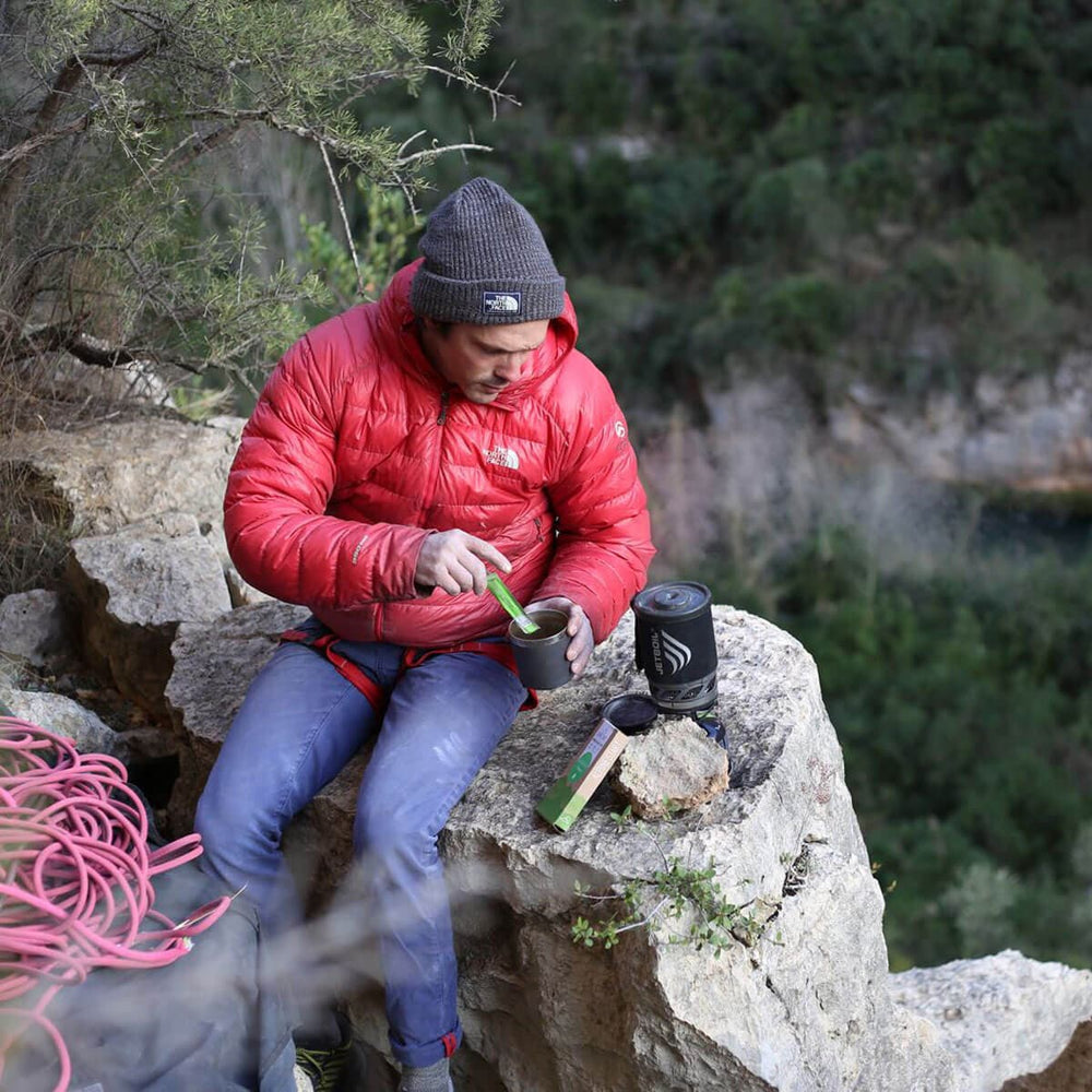 Man cooking on the floor with the Jetboil MicroMo on the mountain