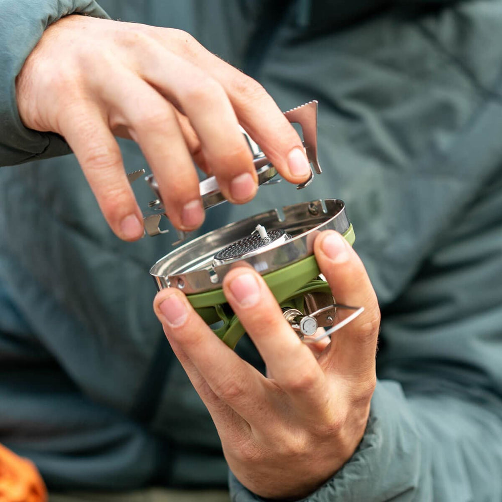 Man putting the Jetboil Pot Support on a stove top