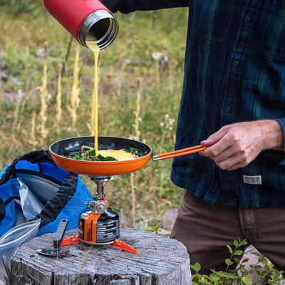 Man pouring egg onto the Jetboil 8 Inch Ceramic Summit Skillet