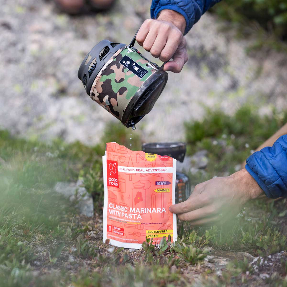 Person Pouring water from the Jetboil MiniMo into a MRE pouch