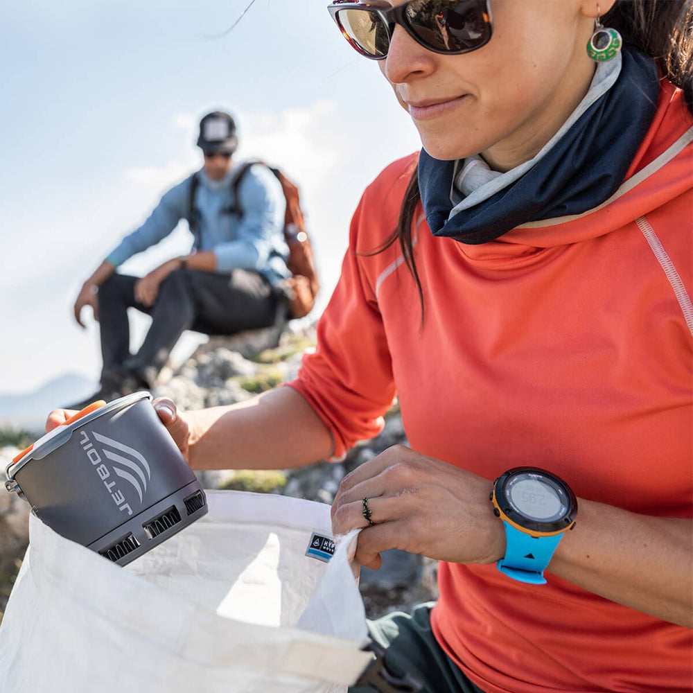 Women taking the Jetboil Stash out of a white bag