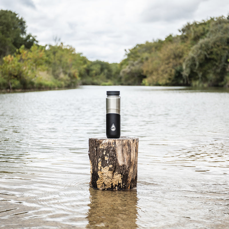 black Berkey® Lookout™ Bottle on a tree stump in a lake