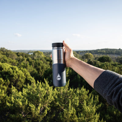 man holding blue Berkey® Lookout™ Bottle with tree view