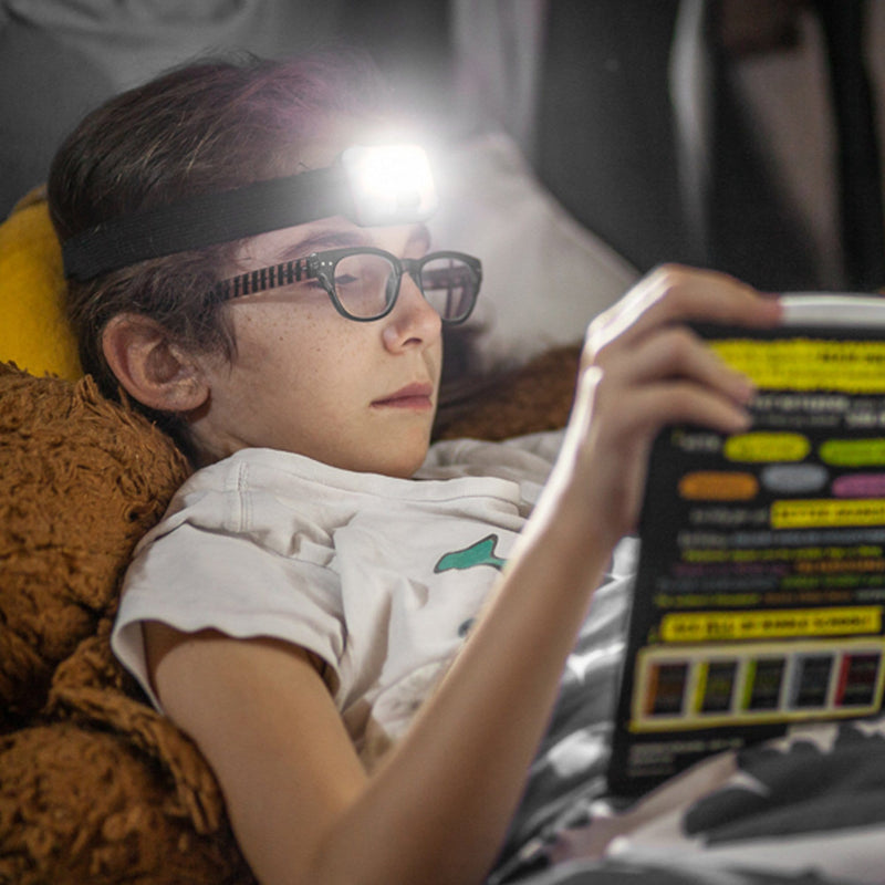 kid using COB LED Headlamp - 200 Lumen while reading a book