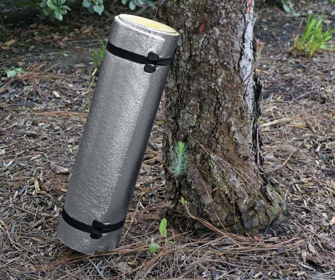 Emergency Double-Sided Outdoor Mattress resting against tree outdoors