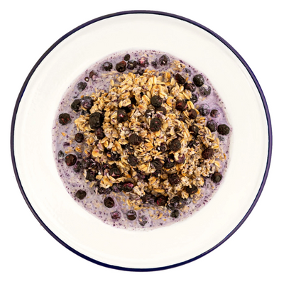 granola with milk and blueberries served on metal plate