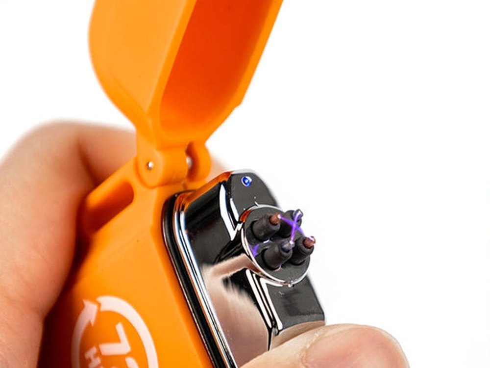 Close-up of the plasma arc firing between the electrodes of the orange lighter