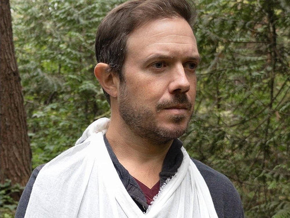 Man wearing the triangular bandage from the kit as an arm sling