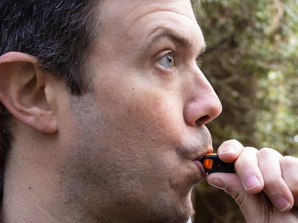 Man blowing the 120-decibel whistle built into the electric lighter